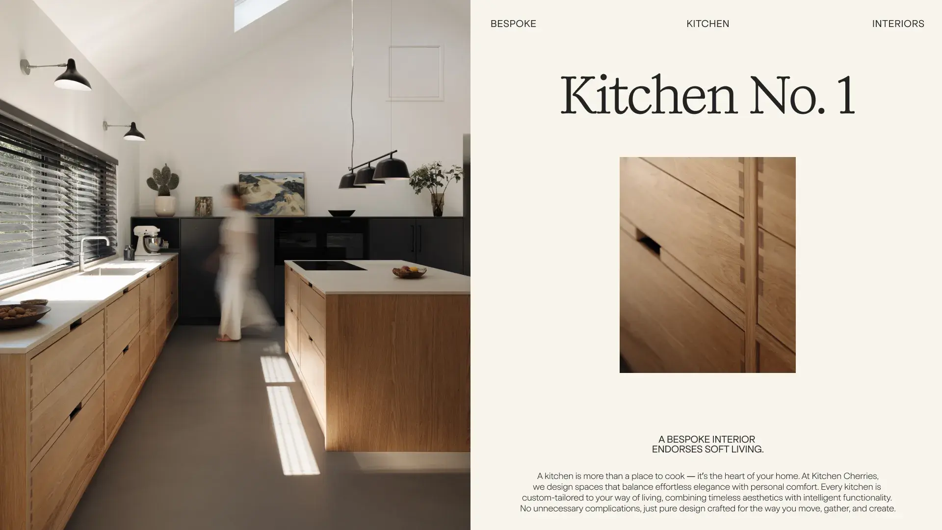 Modern kitchen with wooden cabinets, a central island, and black accents. A person walks through, with sunlight streaming through large windows.