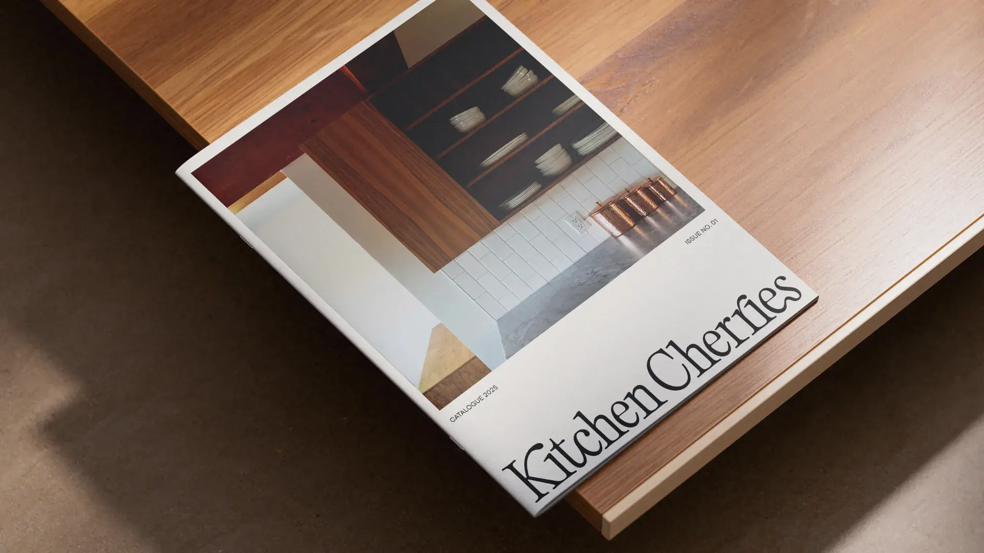 A book titled "Kitchen Cherries" with a cover photo of a modern kitchen featuring wooden cabinets and white tiled walls, resting on a wooden surface.