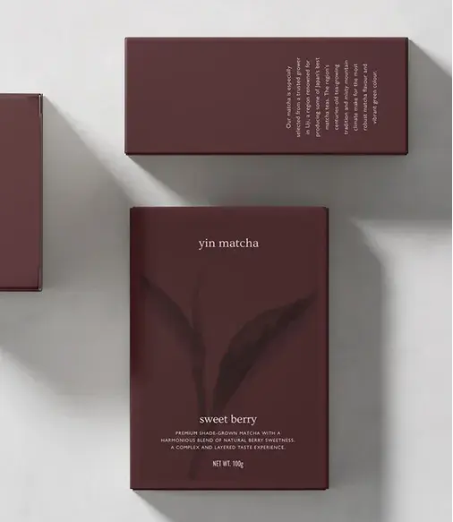 Minimalist packaging for Yin Matcha's "Sweet Berry" flavor. Maroon box with subtle leaf design, white text detailing product information.
